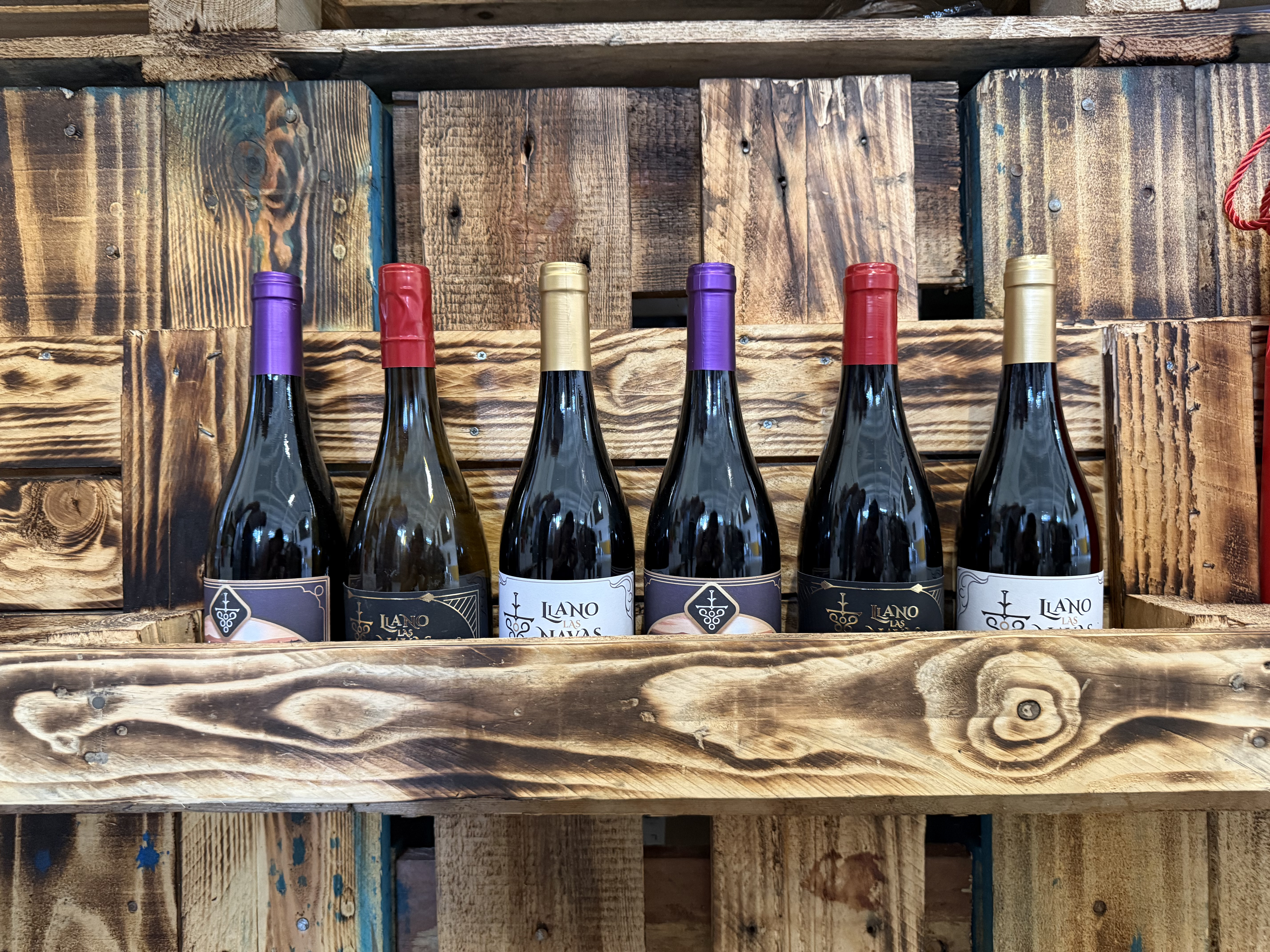 Seis botellas expuestas en palé de madera